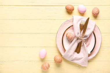 Sarı ahşap arka planda Paskalya yumurtaları olan güzel bir masa.