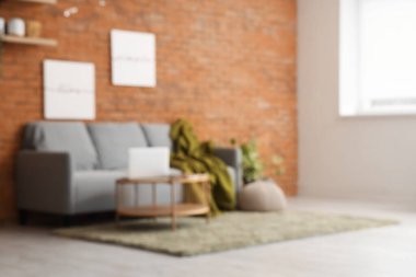 Rahat kanepesi ve masası olan, bulanık manzaralı çatı katı tarzı oturma odası.