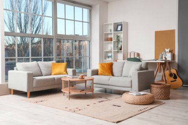 Kanepeleri, kahve masası ve yastıkları olan modern bir oturma odası.