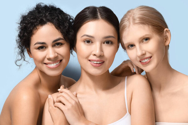 Красивые молодые женщины обнимаются на голубом фоне, крупным планом