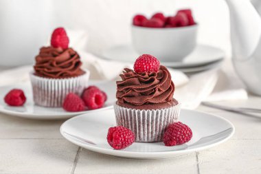 Masada ahududu olan bir tabak lezzetli çikolatalı kek.