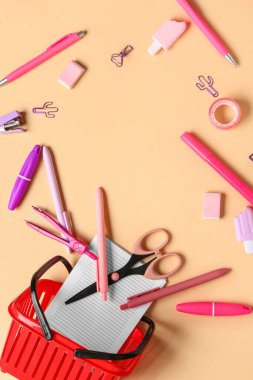 Alışveriş sepetinden yapılmış çerçeve ve renk arkaplanındaki farklı kırtasiye