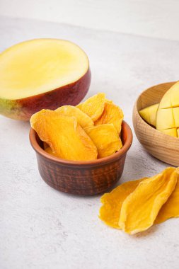 Beyaz arka planda kurutulmuş mango dilimleri ile kase