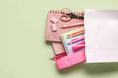 Işık arka planında farklı okul kırtasiyesine sahip alışveriş çantası.