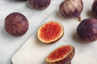 Gri arka planda taze olgun incirleri olan tahta