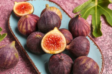 Mor arka planda taze taze incir tabağı.