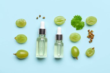 Renkli arkaplanda üzüm tohumu yağı şişeleri olan kompozisyon