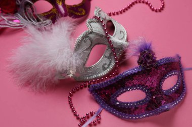 Pembe arka planda karnaval maskeleri