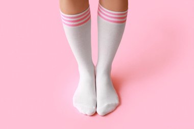 Pembe arka planda beyaz çoraplı genç kadın bacakları
