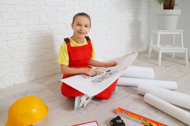 Ev planı olan küçük mimar odada oturuyor.