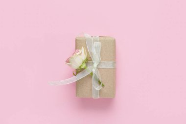 Pembe arka planda güzel bir gül olan hediye kutusu. Uluslararası Kadınlar Günü
