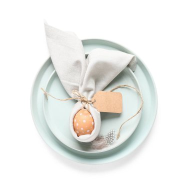 Beyaz arka planda Paskalya yumurtası ve tüyü olan güzel bir masa.