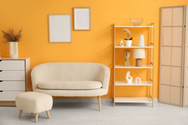 Oturma odasında ayak sehpası olan beyaz rahat bir kanepe.