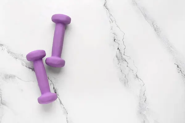 stock image Purple dumbbells on white marble background