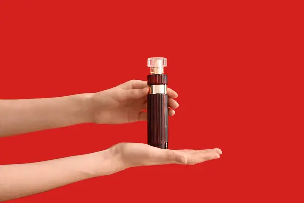 Női Kéz Kezében Palack Parfüm Piros Alapon — Stock Fotó