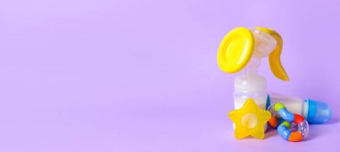 Göğüs pompası ve bebek aksesuarları eflatun arkaplan üzerinde metin için boşluk ile