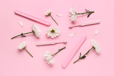 Pembe arka planda diş fırçaları, davalar ve papatya çiçekli kompozisyon