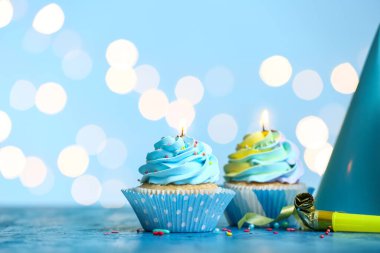 Bulanık ışıklara karşı yanan mumları olan lezzetli doğum günü kekleri.