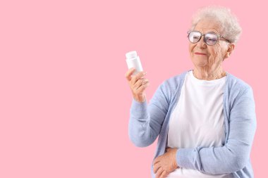 Pembe arka planda ilaç şişesi olan son sınıf öğrencisi kadın.