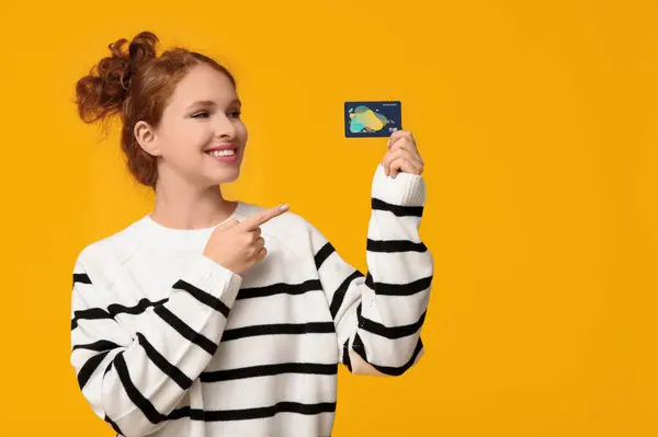 Beautiful Young Woman Pointing Credit Card Yellow Background — Stock Photo, Image
