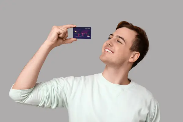Junger Mann Mit Kreditkarte Auf Grauem Hintergrund — Stockfoto