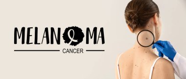 Dermatolojist, arka planda hastanın mol 'lerini inceliyor. Melanoma Kanser Farkındalığı Ayı
