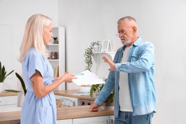 Olgun bir adam ve karısı mutfakta boşanma fermanını imzalamayı reddediyor.