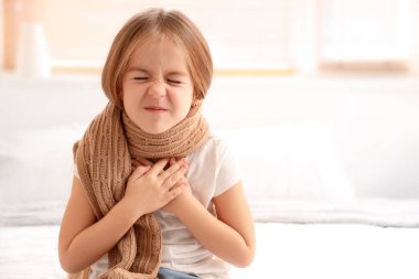 Yatak odasında fularlı hasta küçük kız.