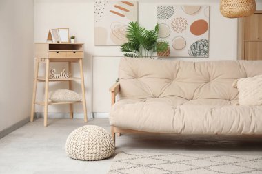 Rahat kanepesi, resimleri ve rafları olan bir oturma odası.