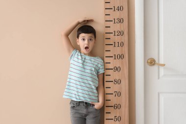 Şok olmuş küçük çocuk, tahta stadyumun yakınındaki yüksekliği ölçüyor.