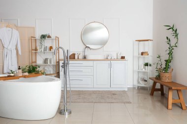 Yuvarlak aynalı bir banyo.