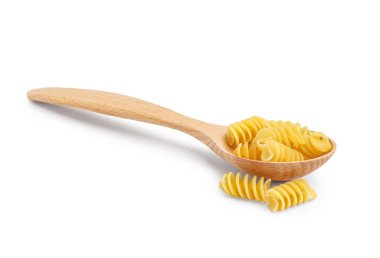 Ahşap kaşık ve beyaz arka planda pişmemiş fusilli makarna.