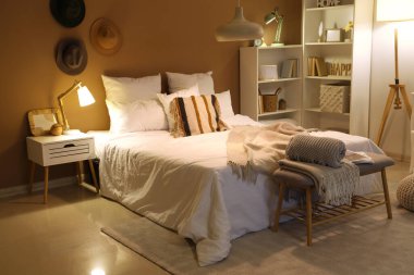 Yatak odasının içinde, yumuşak bankta ekoseler ve geceleri parlayan lambalar.