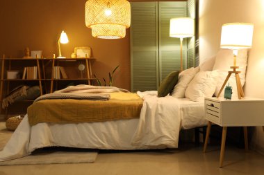 Yatak odasının içinde ekose kumaşlar ve geceleri parlayan lambalar.