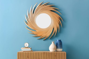 Odadaki mavi duvarda dekorlu ve altın aynalı tuvalet.