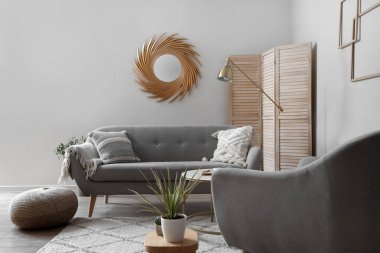 Altın aynalı, kanepeli ve lambalı oturma odasının içi.