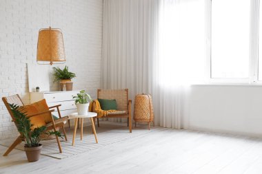 Oturma odasının içinde, koltukları, yastıkları ve çekmeceleri tuğla duvarın yanında.