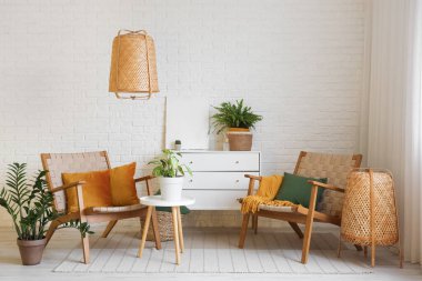 Oturma odasının içinde, koltukları, yastıkları ve çekmeceleri tuğla duvarın yanında.