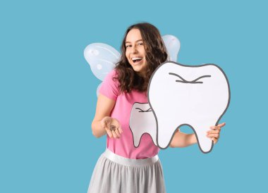 Mavi arka planda kağıt figürlü ve bozuk paralı diş perisi.