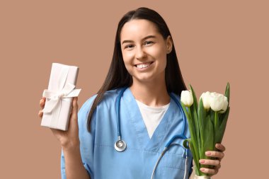 Beyaz laleli bayan doktor ve bej arka planda hediye kutusu. Kadınlar Günü kutlaması