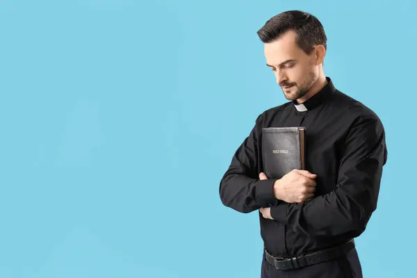 Mavi Arka Planda Kutsal Ncil Tespih Taşıyan Erkek Rahibin Portresi — Stok fotoğraf