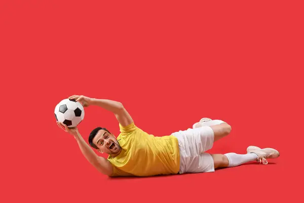 Porträt Eines Männlichen Fußballspielers Der Ball Auf Rotem Hintergrund Fängt — Stockfoto