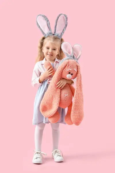 可爱的小女孩 长着小兔子耳朵 粉红背景的毛绒玩具 复活节庆祝活动 — 图库照片