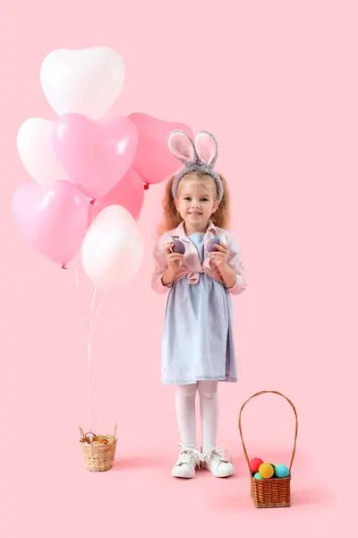 可爱的小女孩 有小兔子耳朵 复活节彩蛋和粉色背景的气球 — 图库照片
