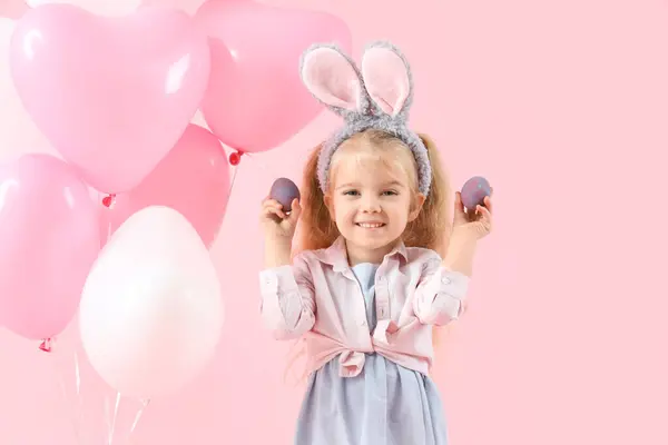 可爱的小女孩 有小兔子耳朵 复活节彩蛋和粉色背景的气球 — 图库照片