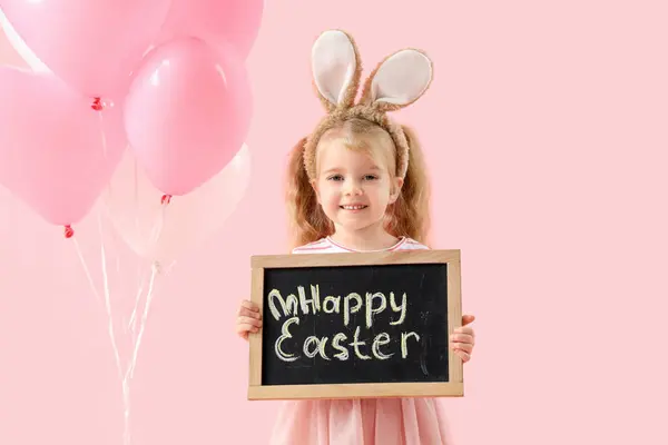 可爱的兔子耳朵小女孩拿着粉红背景的文本Happy Easter黑板 — 图库照片