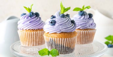 Cam standı ve yaban mersinli lezzetli kekler, yakın plan.