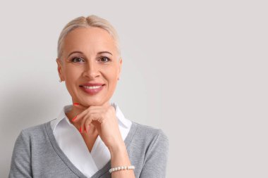 Açık arka planda olgun sarışın kadın, yakın plan.