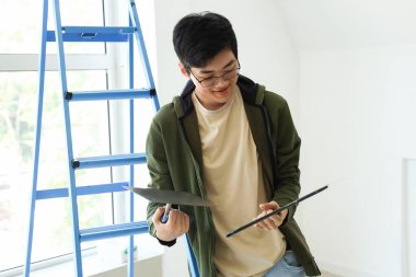 Odasında oyuncak bıçakları olan genç bir Asyalı.