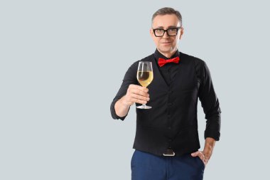 Hafif arka planda şarap kadehi olan olgun bir şarap garsonu.